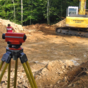 Ingeniero midiendo pendientes y niveles del terreno con equipo topográfico.