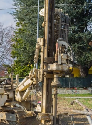 Ingeniero tomando muestras de suelo durante un estudio de mecánica para construcción.